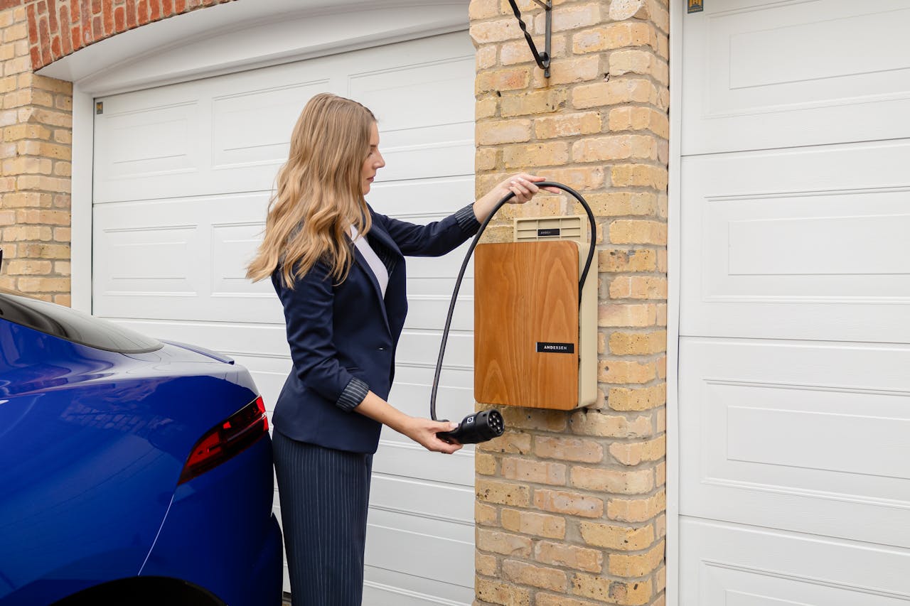 Mastering the First Impression: Your intriguing post title goes here A woman using a home electric vehicle charger on a brick wall in a garage.